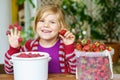 Portrait of happy little preschool girl eating healthy strawberries and raspberries. Smiling child with ripe berries Royalty Free Stock Photo