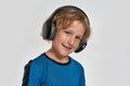 Portrait of happy little sportive boy child in sportswear and headphones smiling at camera while posing, standing Royalty Free Stock Photo