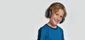 Portrait of happy little sportive boy child in sportswear and headphones smiling at camera while posing, standing Royalty Free Stock Photo