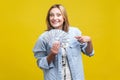 Portrait of happy lottery winner, pointing at fan of dollars, looking at camera with toothy smile.  on yellow background Royalty Free Stock Photo