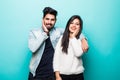 Portrait of happy lovely indian couple smiling and posing on camera while pleasend signs together over green background Royalty Free Stock Photo