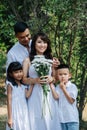 Portrait of a happy loving asian family in white clothes in a park