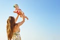 Portrait of happy loving mother and her baby outdoors. Mother and child against summer blue sky. Royalty Free Stock Photo