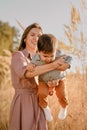 Portrait of happy loving mother hugging her baby son in the sunny park near river Royalty Free Stock Photo