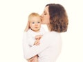 Portrait of happy loving mother kissing her baby on a white Royalty Free Stock Photo