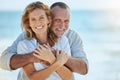 Portrait of happy and loving retired mature caucasian couple enjoying a romantic date at the beach on a sunny day Royalty Free Stock Photo