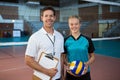 Happy male coach and volleyball player standing in the court Royalty Free Stock Photo