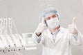 Portrait of happy male dentist wearing lab coat while sitting in clinic Royalty Free Stock Photo