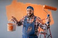 Portrait of happy male house painter worker with painting roller Royalty Free Stock Photo
