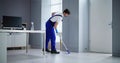 Portrait Of Happy Male Janitor Cleaning Floor Royalty Free Stock Photo