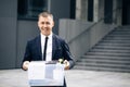 Portrait happy male office worker with box of personal stuff. Unemployment concept. Left without money. Businessman lost