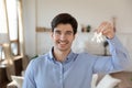 Portrait of happy male renter show keys to own home