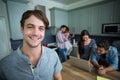 Portrait of happy man with friends in background at home Royalty Free Stock Photo