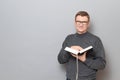 Portrait of happy man holding book in hands and smiling cheerfully