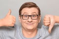 Portrait of happy man showing thumb up and thumb down gestures Royalty Free Stock Photo