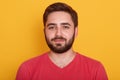 Portrait of happy man standing and looking directly at camera with pleased facial expression, bearded male wearing red casualt Royalty Free Stock Photo