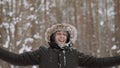 Portrait of man in winter forest. Guy throws snowball, slaps, snow flies.