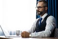 Portrait of happy mature businessman bearded wearing glasses and suite on dark background