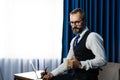 Portrait of happy mature businessman bearded wearing glasses and suite on dark background