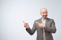 Portrait of a happy businessman in casual suit pointing finger away over white background Royalty Free Stock Photo