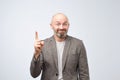 Portrait of a happy businessman in casual suit pointing finger away over white background Royalty Free Stock Photo