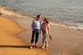 Portrait of happy mature couple walking along a sandy beach Royalty Free Stock Photo