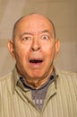 Portrait of a happy mature man doing funny faces and posing for camera in a blurred background Royalty Free Stock Photo