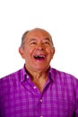 Portrait of a happy mature man laughting very loud and wearing a purple square t-shirt in a white background Royalty Free Stock Photo