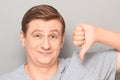 Portrait of happy mature man showing thumb down gesture Royalty Free Stock Photo