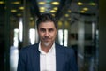 Portrait of happy mature man smiling and looking at camera. Confident businessman wearing suit, standing in office building Royalty Free Stock Photo