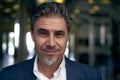 Portrait of happy mature man smiling and looking at camera. Confident businessman wearing suit, standing in office building Royalty Free Stock Photo