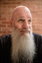 Portrait of happy mature man smiling and thinking with long gray beard Royalty Free Stock Photo