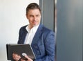 Portrait of happy mature man. Confident businessman wearing suit, using tablet. Royalty Free Stock Photo