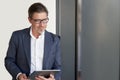 Portrait of happy mature man wearing glasses. Confident businessman in suit, using tablet. White background Royalty Free Stock Photo