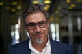 Portrait of happy mature man wearing glasses, looking at camera. Confident businessman wearing suit, standing in office building Royalty Free Stock Photo