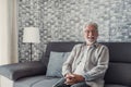 Portrait of happy mature 80s man sit on couch at home look at camera posing relaxing on weekend, smiling positive senior 70s Royalty Free Stock Photo