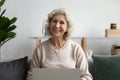 Portrait of happy mature 60s woman using laptop at home Royalty Free Stock Photo