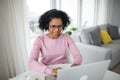 Portrait of happy mature woman with headset working on laptop indoors, home office concept. Royalty Free Stock Photo