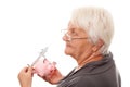 Portrait of a happy mature woman holding piggy bank isolated against white Royalty Free Stock Photo