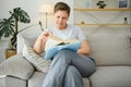 Portrait of a happy mature woman relaxing on couch and reading a book in a modern house Royalty Free Stock Photo