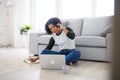 Portrait of happy mature woman working on laptop and making phone call indoors, home office concept. Royalty Free Stock Photo