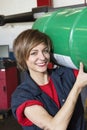 Portrait of a happy mechanic carrying oil drum in vehicle repair shop