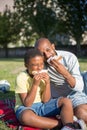 Portrait of happy man and boy having snack in park Royalty Free Stock Photo