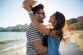 Happy man embracing his girlfriend putting him hat on head