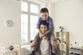 Portrait of happy loving young father carrying his little son on shoulders and smiling Royalty Free Stock Photo