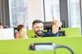 Portrait of happy mid adult businessman wearing headset while gesturing thumbs up in office Royalty Free Stock Photo