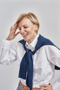 Portrait of happy middle aged caucasian woman wearing business attire touching her head while smiling, posing isolated Royalty Free Stock Photo