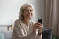 Portrait of happy middle aged female customer holding smartphone