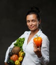 Portrait of a happy middle-aged woman holds a basket of fresh vegetables and fruit Royalty Free Stock Photo