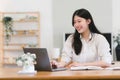 Portrait of a happy millennial Asian businesswoman working remotely in her home office. Royalty Free Stock Photo